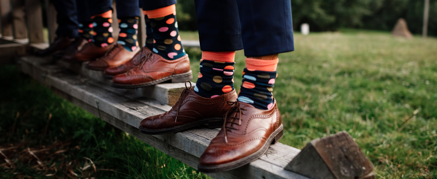 People wearing patterned socks and brown shoes on a wooden step outdoors.