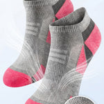 Gray and pink socks with breathable mesh ventilation on a light gray background
