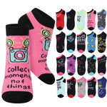 A set of low-cut socks shown on a plain white background, with two larger pink-and-black socks in front and a grid of smaller color variants behind them. The front socks feature a camera graphic and the phrase 'Collect moments not things.