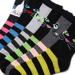 Four pairs of novelty socks arranged diagonally, each featuring a different cat face design with colorful embroidered eyes, noses, and whiskers, paired with bold horizontal stripes in various color combinations.