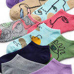Colorful socks with cartoon-like designs arranged on a white background