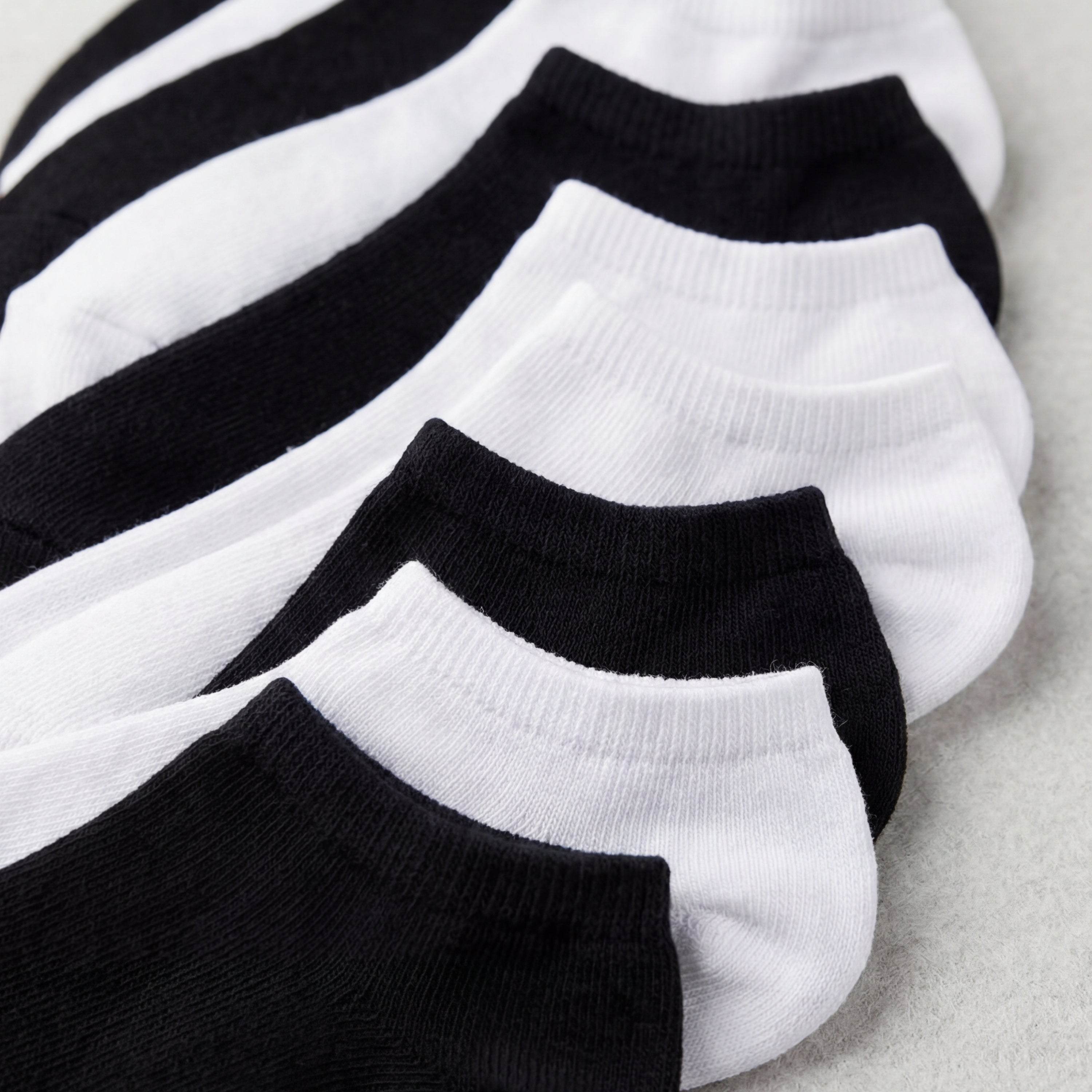 Set of black and white ankle socks on a light gray background