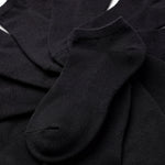 Stack of black ankle socks on a white background