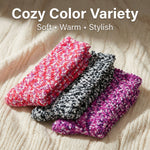 Three knitted socks in pink, black, and purple on a textured surface with 'Cozy Color Variety' text.