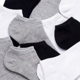 Set of black, gray, and white ankle socks on a light background