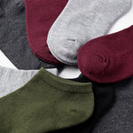 Set of colorful socks including green, gray, maroon, and black on a white background