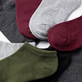 Set of colorful socks including green, gray, maroon, and black on a white background