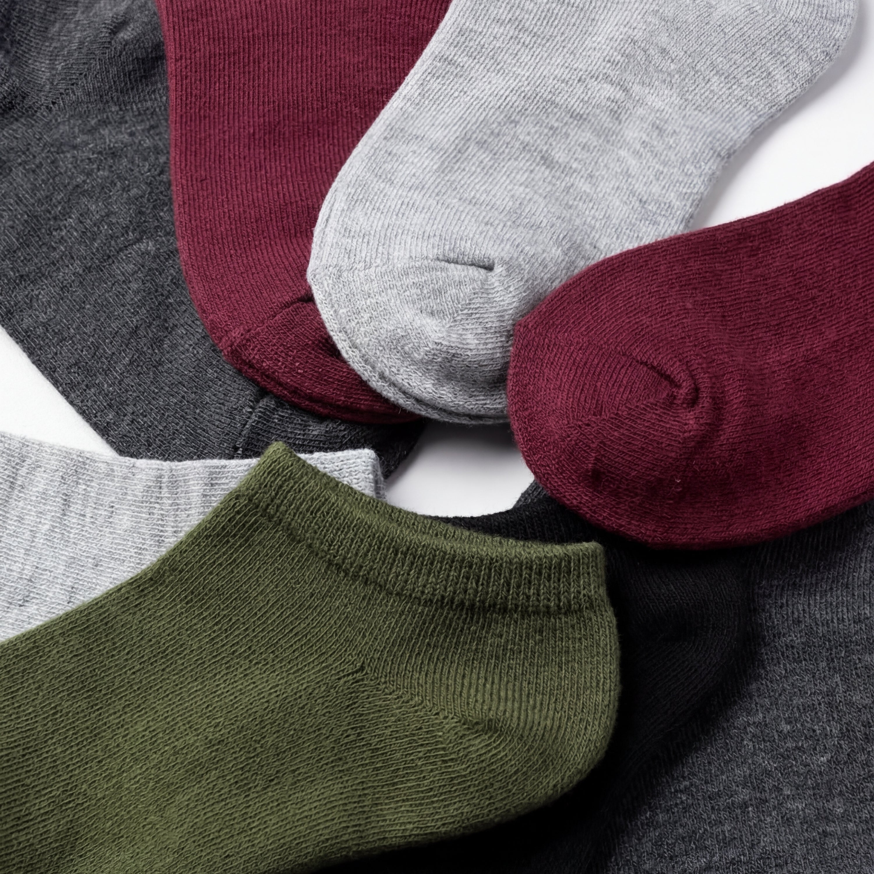 Set of colorful socks including green, gray, maroon, and black on a white background