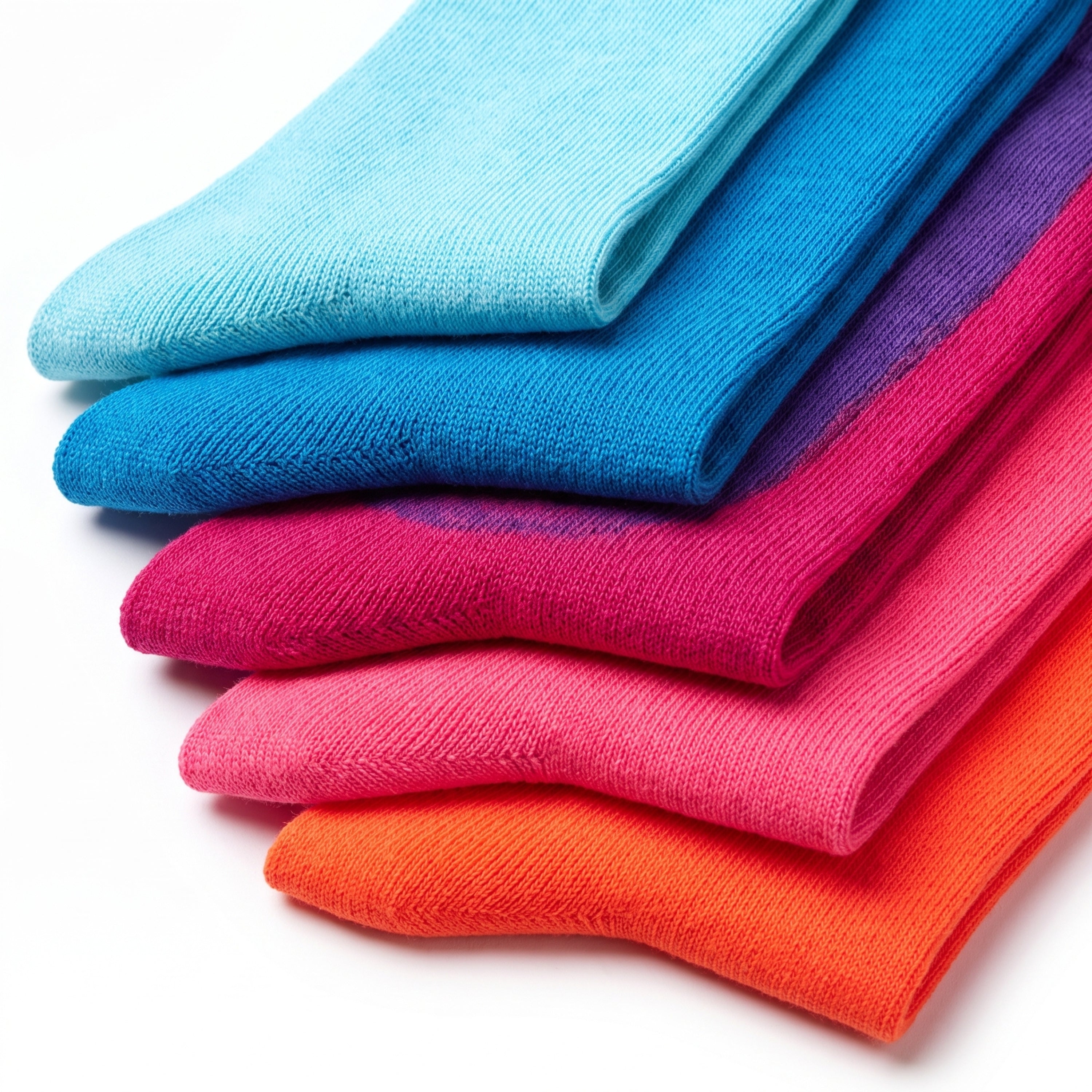 A stack of folded knit socks in a bright gradient of colors, including light blue, medium blue, purple, magenta, pink, and orange, on a white background.