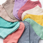 Assorted colorful socks arranged in a circular pattern on a light background