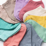 Assorted colorful socks arranged in a circular pattern on a light background