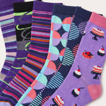 Six pairs of colorful patterned socks fanned out on a white background. The designs include stripes, abstract shapes, and cupcake motifs in purple, pink, blue, orange, and black.