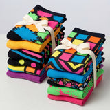 Stacks of colorful patterned socks with ribbons on a light gray background