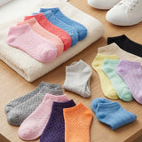 Colorful socks arranged on a wooden surface with a towel underneath.