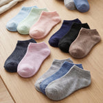Assorted colorful socks on a wooden surface