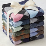 Stack of colorful argyle socks tied with a ribbon on a light background