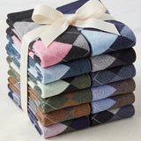 Stack of colorful argyle socks tied with a ribbon on a light background