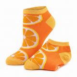 A pair of low-cut ankle socks with a bright orange and yellow citrus slice pattern, displayed on a clean white background.
