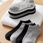Set of gray, black, and white socks on a wooden surface