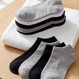 Set of gray, black, and white socks on a wooden surface