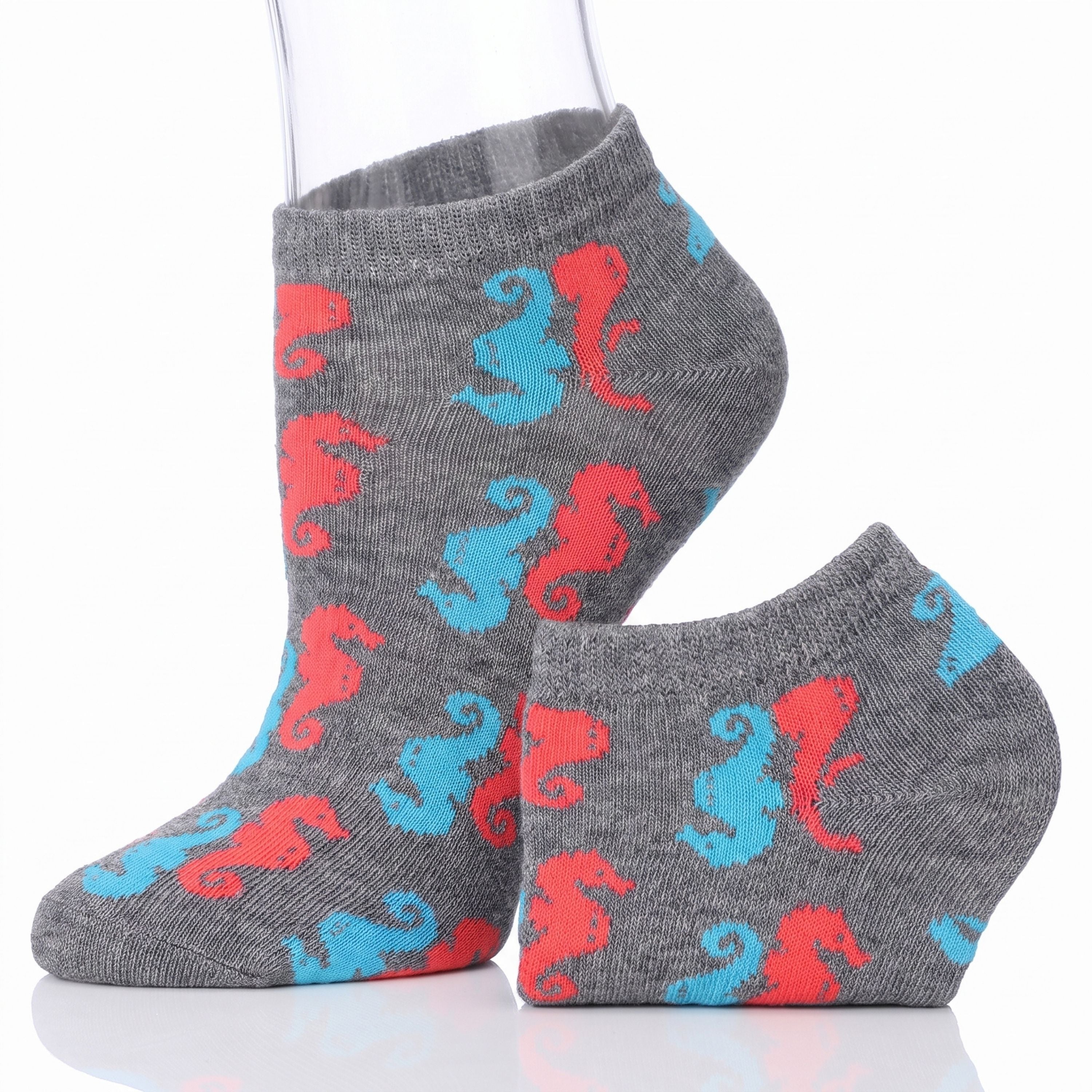 A pair of low-cut ankle socks on a white background, featuring a gray heather base with a repeating pattern of red and light blue seahorses.