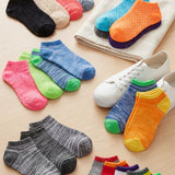 Colorful socks arranged on a light surface with a sneaker.