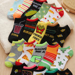 Colorful socks with various food-themed designs on a wooden surface.