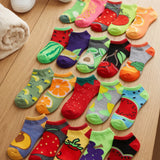 Colorful fruit-themed socks arranged on a wooden floor.