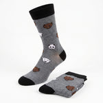 A pair of gray crew socks with black cuffs, heels, and toes, featuring a playful pattern of cartoon polar bear and panda faces, shown with one sock standing upright and the other folded on a white background.