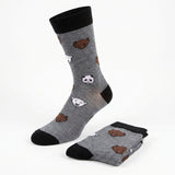 A pair of gray crew socks with black cuffs, heels, and toes, featuring a playful pattern of cartoon polar bear and panda faces, shown with one sock standing upright and the other folded on a white background.