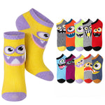 A set of novelty low-cut socks featuring cartoon monster faces, with two large yellow socks in the foreground and a row of smaller multicolor socks in the background on a white studio background.