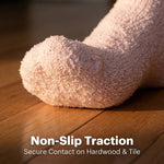 Close-up of a sock with non-slip traction on a wooden floor, emphasizing the product feature.
