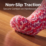 Red and white textured sock on a wooden floor with text 'Non-Slip Traction' and 'Secure Contact on Hardwood & Tile'.