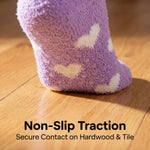 Purple sock with white hearts on a wooden floor, emphasizing non-slip traction.