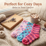 Colorful socks on a soft surface with a mug of hot chocolate, book, and yarn.