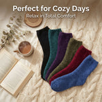 Set of colorful socks on a textured surface with a cup of coffee, book, and plant.