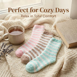 Pair of striped socks on a soft blanket with a cup of tea, book, and lavender flowers.