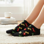 Black socks with colorful bow patterns worn by a person on a carpeted floor.