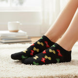 Black socks with colorful bow patterns worn by a person on a carpeted floor.