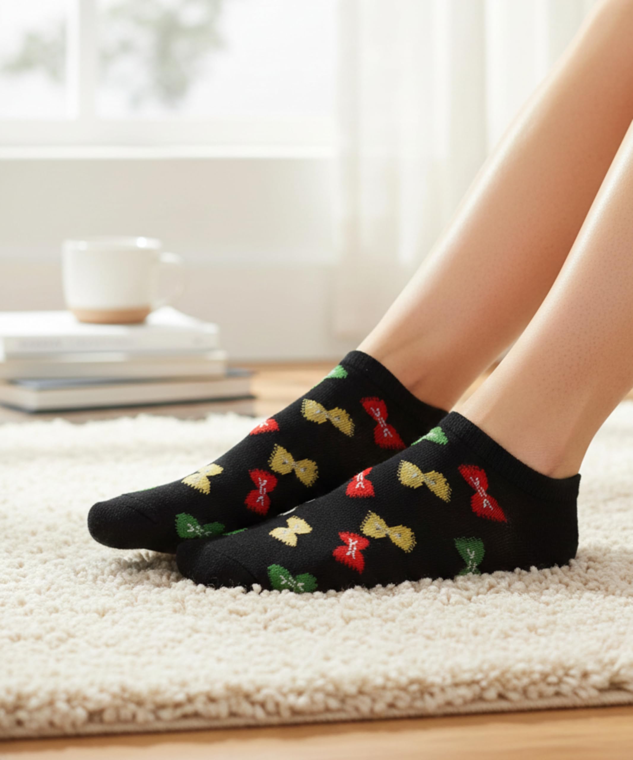Black socks with colorful bow patterns worn by a person on a carpeted floor.