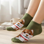 Green socks with dog design worn by a person indoors.