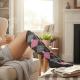 Person wearing argyle socks sitting on a couch with a cup and book in a cozy living room.