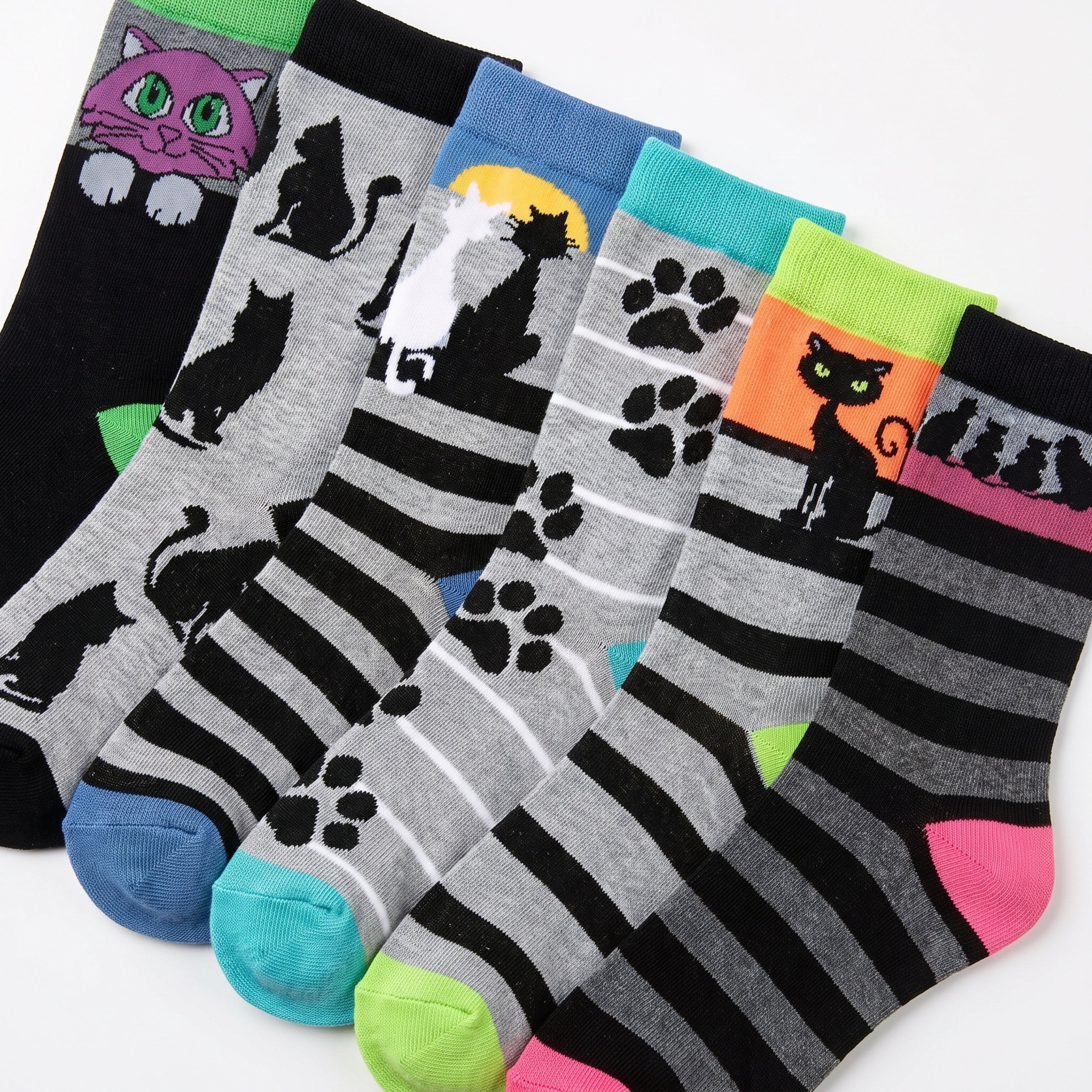 Six pairs of novelty socks with cat-themed patterns, displayed in a fan arrangement on a white background. The socks feature black and gray stripes, cat silhouettes, paw prints, and colorful accents in pink, green, blue, and orange.