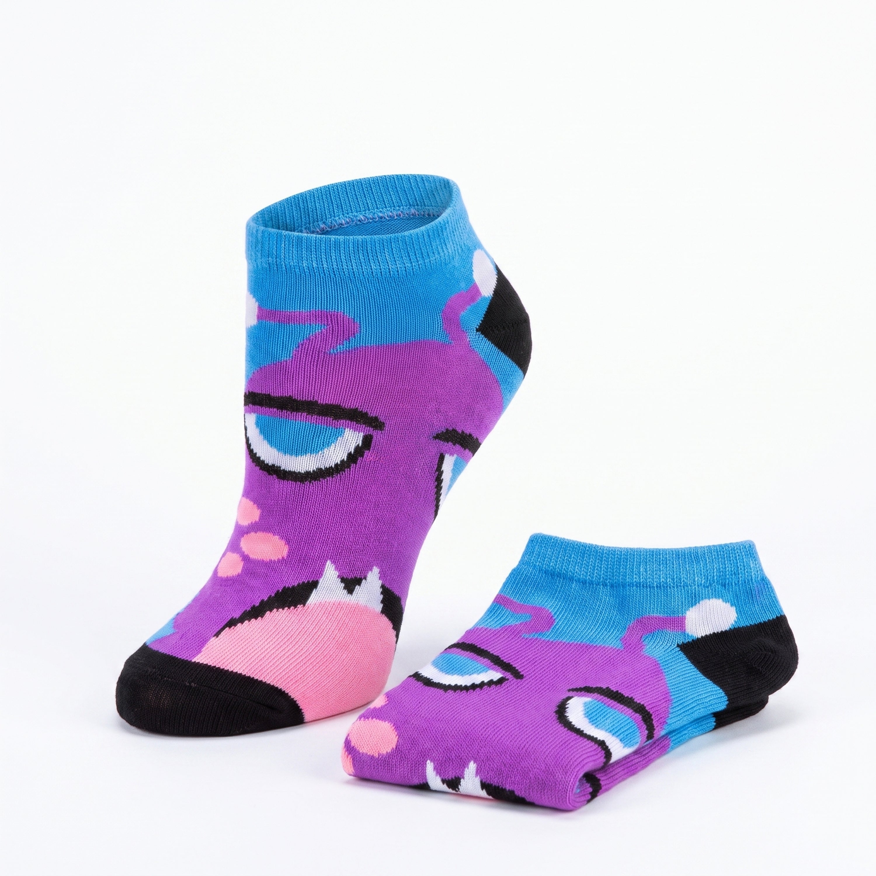 A pair of low-cut ankle socks featuring a cartoon monster face design in purple, blue, pink, and black, displayed on a clean white background.