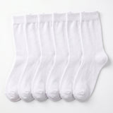 Six pairs of plain white crew socks arranged side by side on a clean white background.