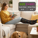 Woman sitting on a couch wearing colorful socks with a dog, holding a book and a mug, size chart overlay.