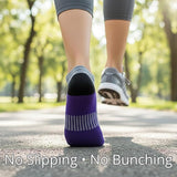 Person wearing purple socks with text 'No Slipping • No Bunching' on a blurred outdoor background