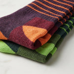 Stack of colorful striped socks on a light background