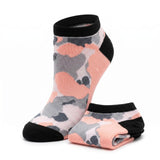 A pair of low-cut ankle socks featuring a pink, gray, and white camouflage pattern with solid black cuffs, heels, and toes, displayed on a clean white background.