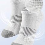 White socks with gray toes and heels on a light blue background, highlighting breathable mesh ventilation.